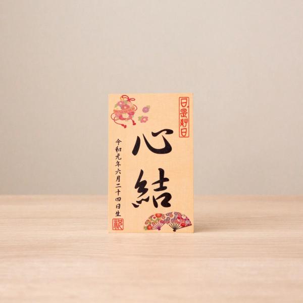 サイズ：横幅8×奥行6.5×高さ13cmお人形や羽子板の脇にお飾り頂く、お名前・生年月日入りの立札です。丸々と跳ね回る元気な娘に育てとの願いが込められた花鞠と、末広がりを願う扇のデザインです。木板は木肌が滑らかで硬いブナ材を使用。 板へ直接...
