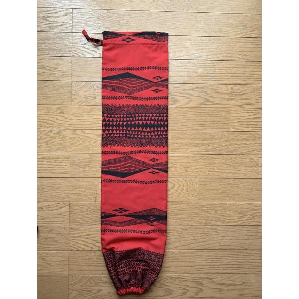 赤と黒のカヒコ柄のパウスカートケースです。ハワイ直輸入のファブリックを、当ショップにてハンドメイド仕上げしております。仕上がり寸法: 長さ82cm、周り42cm柄の出方はそれぞれ異なりますので、ご了承ください。ケース上部は共布ヒモで縛るタイ...