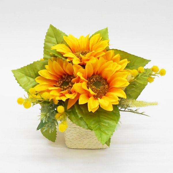 小さいサイズのサンフラワーポット。邪魔にならない大きさです。夏のテーブル・カウンター飾り等にお勧めです。※ヒマワリ以外の添え花・葉は変わる場合がございます。あらかじめご了承ください。高さ：約16cm花径：約9cm　7輪ポット：ペーパーロープ...