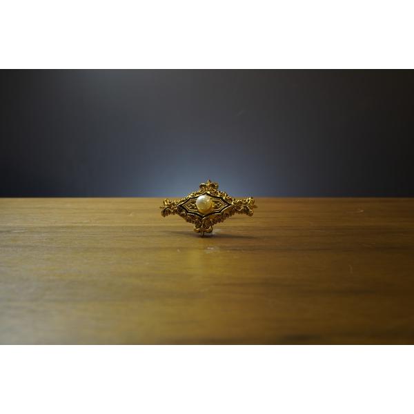 唐草模様にパールオブジェの入った飾り鋲です。２か所の鋲穴で留めます。素材：アルミ　金色加工サイズ：55×33