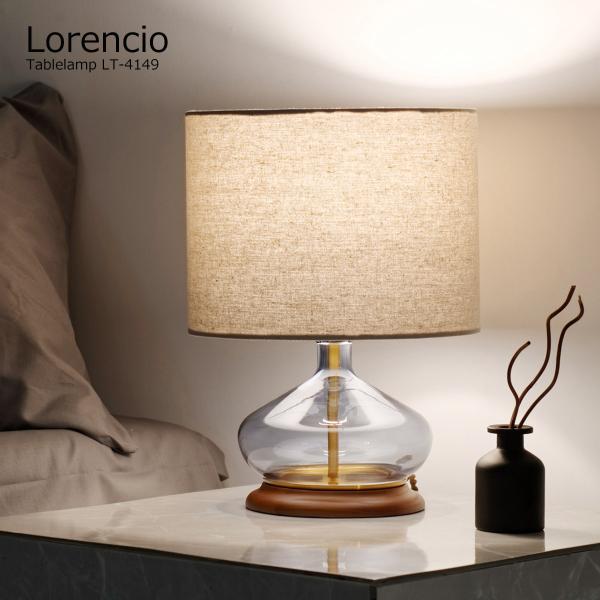 曲線が美しいブルーグレーのガラスにファブリックのシェード、ウッドベースという異なる素材を組み合わせながらも品のあるシックなたたずまいに仕上げたテーブルライト。ガラスの内側にはゴールドカラーの支柱とプレートが配置されていてアクセントになってい...