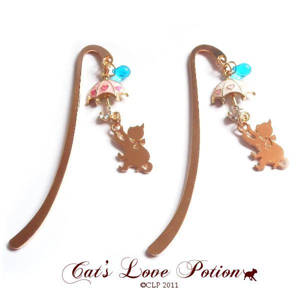 サイズ：ブックマーカー：約8.5cm　傘チャーム：18×17mmラインストーン：4mmチェコドロップ：7×5mm猫チャーム：約20×17mm 傘を持ったねこの雨降りのミニブックマーカーです。 ミニサイズで邪魔にならないので文庫本や手帳などの...