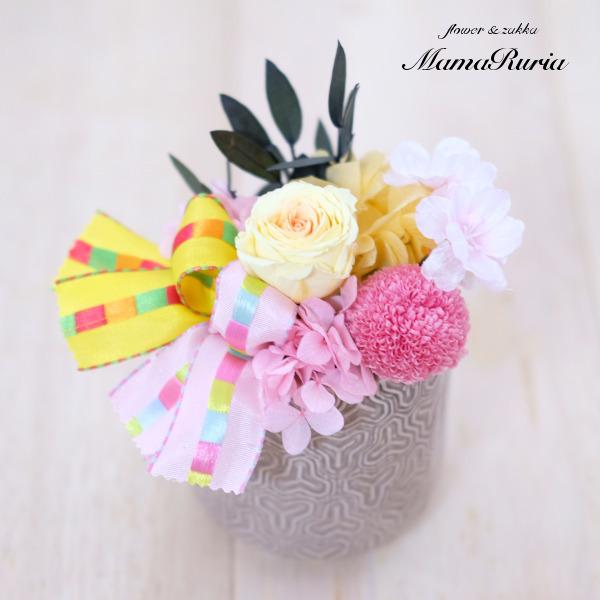 黄色のバラとピンクのマム、桜のアーティフィシャルフラワーのかわいいアレンジです。リボンも黄色とピンクの２色使いで、華やかさをプラス！和風の器で、かわいらしさだけでなく、落ち着いたイメージも母の日の贈り物や、お誕生日のお祝いなど、用途は様々。...