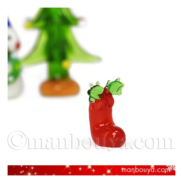 とっても小さいクリスマスブーツのガラス細工。真っ赤なブーツに柊の葉のグリーンが映えて、とてもかわいいです。プレゼントボックスやクリスマスツリーなどと組み合わせての飾り付けにおすすめです。【サイズ】約高さ1.7×幅1.2×奥行1cm※小さい商...