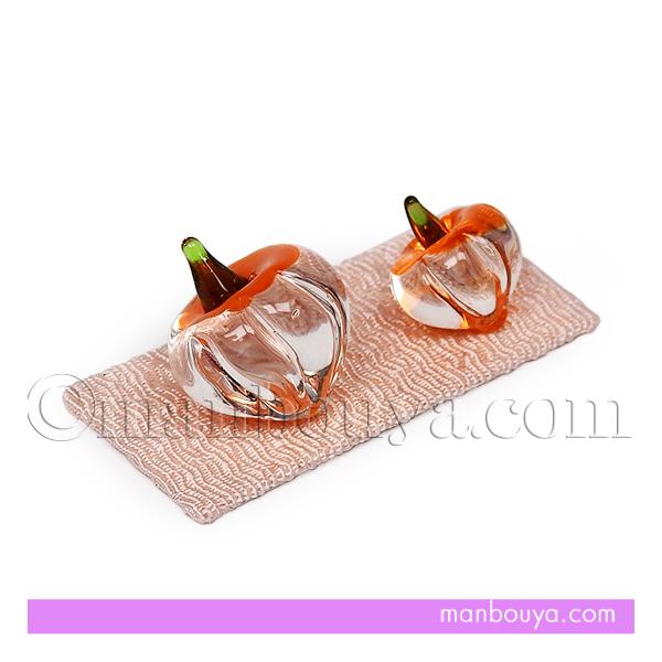 とっても小さいガラスのホオズキ。サイズの違う2個のほおずきと、かわいいピンクのちりめん台のセットです。クリアなホオズキは、ヘタの周りと先だけがオレンジになっています。透明な部分にオレンジ色が映り込み、見る角度によって表情が変わり、とても綺麗...