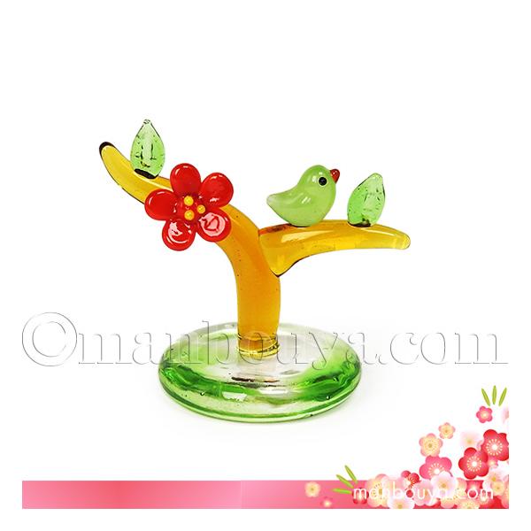 台座付きの梅の木にうぐいすが乗ったガラス製置物。枝に咲いた一輪の赤い花。春告鳥ともいわれるうぐいす。「梅に鶯」は美しく調和するもののたとえにもなっていて、お正月や新春の飾りにぴったり。グリーンが入った台座も、春の芽吹きが感じられます。【サイ...