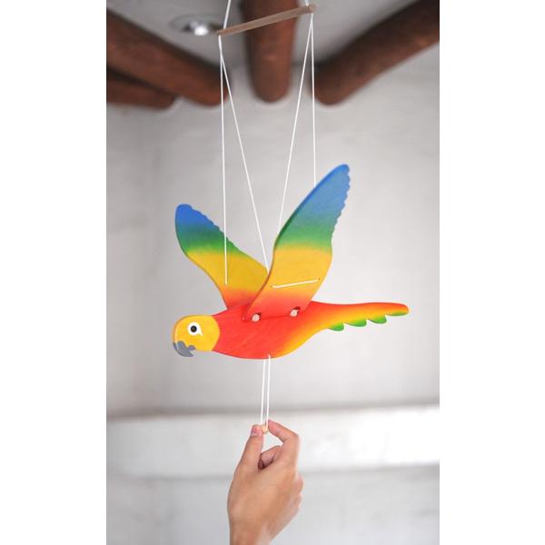 オストハイマー社の中でもとりわけカラフルな木製モビールです。美しい色合いが魅力のオウムを、お部屋のインテリアとして飾られてはいかがでしょうか？　ひもを引っ張るとオウムが羽ばたき、まるで話しかけてくれているかのような表情でかわいいですよ。オス...