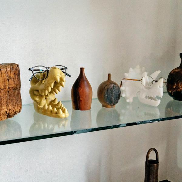 恐竜の骨をモチーフにした樹脂製のメガネホルダー。 オブジェとしても様になる大胆さと遊び心のあるアイテムです。 メガネ置きとしてはもちろん、角や歯をリングホルダーに見立てたり、空洞部分にペンを差し込んだり。 スケルトンの形状を活かして、型には...