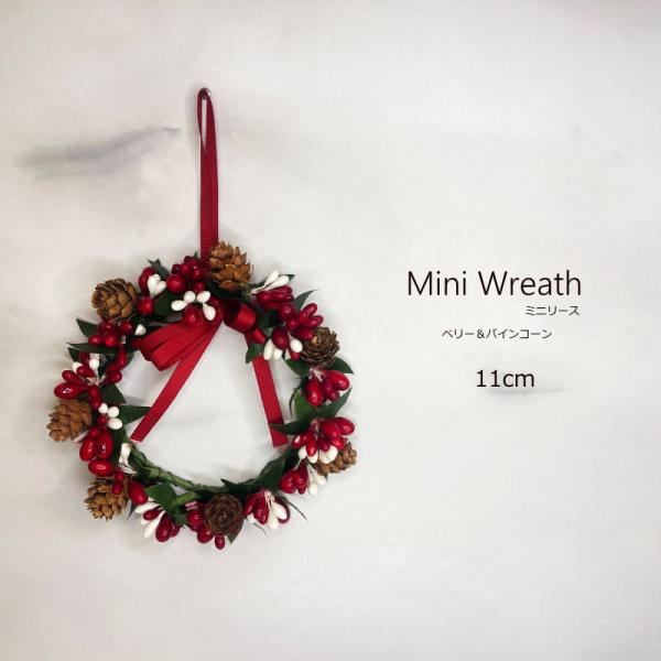 11ｃｍベリー＆パインコーンミニリース　ーーーサイズーーー高さ：約11ｃｍ（紐含まず）横幅：約11ｃｍ厚み：約3ｃｍ重さ：約52ｇご注意装飾の際にラメ（金粉）が手に付いたり落ちたりしますがクリスマス装飾品ですのでご了承ください。ラメの付いた...