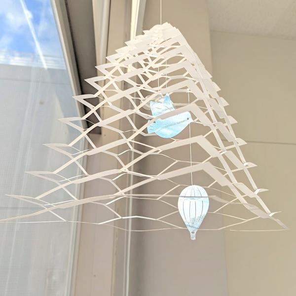 「石川県 金沢 ペーパー モビール」は紙と糸だけで作られたモビールです。パーツを自分で切り取って自由なカタチで飾れます。平らな状態の本体を伸ばして、真ん中から吊るとツリー型に、外側2か所を吊るとかご型になります。その他、お好きな場所で吊って...