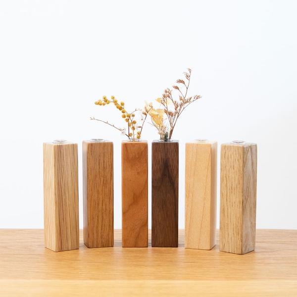 天然無垢材で作られた卓上の一輪挿し。さりげなく飾れる四角柱が登場いたしました。ガラス瓶付きのお洒落なデザインで、お部屋のインテリアに自然に馴染む小さめサイズで飾りやすい。■ カラー：くるみ、ホワイトオーク、ブラックチェリー、ブラックウォルナ...
