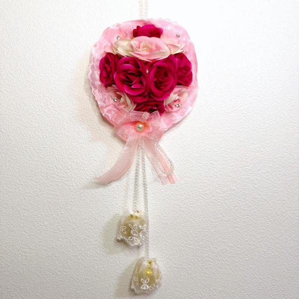 造花とレースのコラボレーションがとてもステキです。お部屋のインテリアやドアノブなどにかけて飾ってください。きれいな鈴の音に癒されます。サイズ：長さ40cm×幅17cm