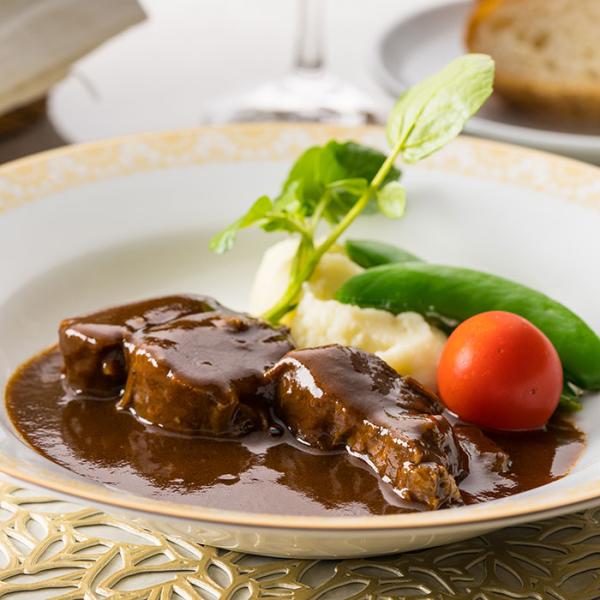 赤ワインとデミグラスソースでじっくりと煮込まれた牛すね肉は、ほろほろと崩れそうな柔らかさ。赤ワインの風味を感じる芳醇なソースと共に食べれば至福の時が訪れる。お好みでマッシュポテトや野菜を添えて。