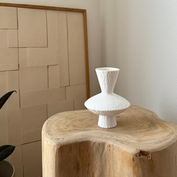 こちらの花瓶は、シンプルでありながらも目を引くデザインが魅力です。白を基調とした色と質感が、どんなインテリアにも自然に馴染みます。高さ12cm、幅10cmとコンパクトなサイズなので、小さなスペースにも置きやすく、デスクや棚の上にさりげなく飾...