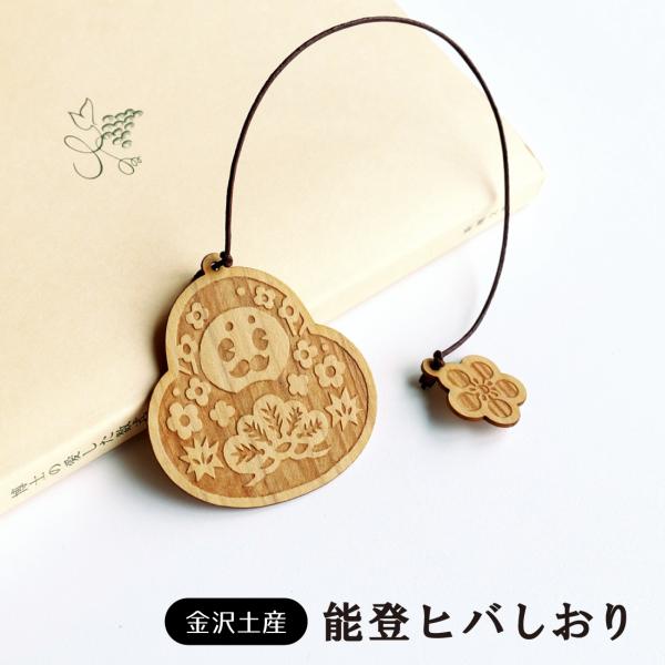 読書タイムに寄り添う“ひゃくまんさん”本や手帳にはさんでお楽しみください。石川県の県木「能登ヒバ（アテ）」に彫刻された、ほっこり可愛いデザイン♪本に挟めば紐の先についている「梅鉢紋」が本から、ちょっこり頭をだしてくれます。※紐のカラーや仕様...