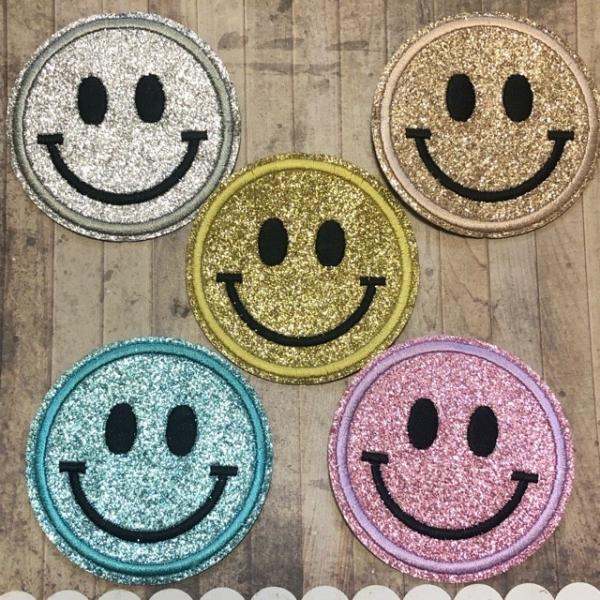 アイロンで接着できるスマイルフェイスのアップリケです。縫製上余分な糸が出てる箇所がございますので、気になる場合はリッパーやハサミで取り除いて下さい。裏接着面はレーザーカット時の熱による黒ずみや滲みがある箇所がございます。カバンや帽子、手芸の...