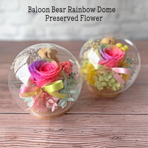 ガラスドームプリザーブドフラワーレインボーローズとテディベアが風船の中に入っているような、バルーンアート仕様のプリザーブドフラワーです。開けた瞬間にほっこりするフラワーギフトはいかがですか？3色のくまさんがレインボーローズを抱えたかわいいデ...