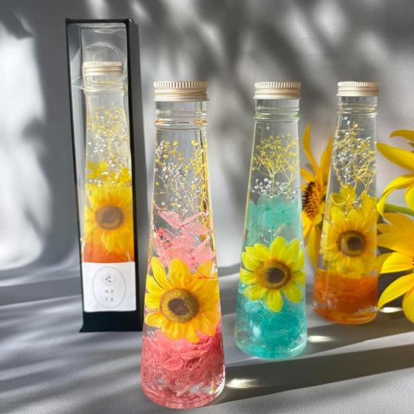 ひまわりハーバリウム　カラーセラピー全３色ひまわりを際立たせる色とりどりのハーバリウムボトルです。瑞々しさと透明感が美しい、カラーボトルになっています。タグは用途に合わせてお選びください。カラーは全３色。■カラー■★ピンク★オレンジ★スカイ...