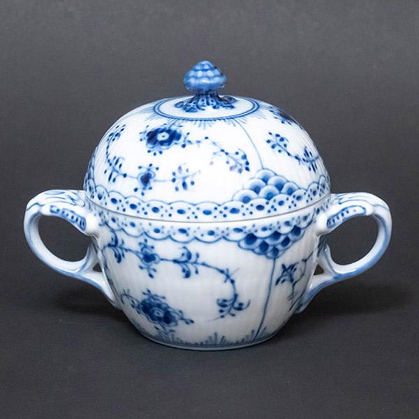 ロイヤル・コペンハーゲンの代表作、ブルーフルーテッドハーフレースのシュガーボウル。ハーフレースは3種類あるブルーフルーテッドのデザインで最後に登場したもので、地模様とレース飾りのバランスが秀逸な一品です。一つ一つ職人による手書きなので、よく...