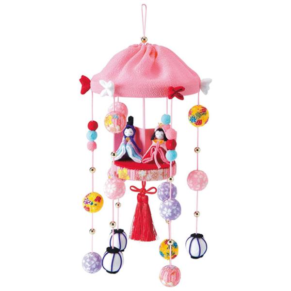 手毬や雪洞の下げ飾りの中、桃色の傘の下でお内裏様とお雛様が台に乗っている、かわいいデザインのつるし雛。傘飾りは「末広がり」で縁起が良く、めでたさの象徴、和傘には「降り注ぐ困難から守る」意味があると言われています。縫い針・縫い糸不要。縫わずに...