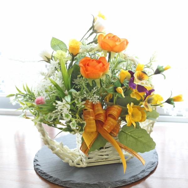 造花 満月かごに入ったオレンジのラナンキュラスとビオラのアレンジ
