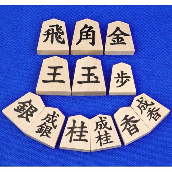 　木製将棋駒の楓押彫駒一字（裏黒字・成付）です。将棋駒の木地は楓材で押し字のやや軽量な将棋駒です。字は一字書で裏面の字は黒字、銀・桂・香の駒の裏面は成付きになっています。　彫り字の駒ではなく押彫の駒ですが、字に微小にくぼみが付いていますので...