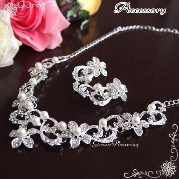 お花をモチーフとしたデザインのキラキララインストーンにパールビジューが付いた上品で華やかなデザインのネックレスとイヤリングですブライダル会場のライトアップやお日さまのしたで胸元でキラキラと輝きますお手頃価格で綺麗可愛いネックレスセットです挙...