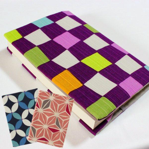古くから着物の柄として親しまれている模様を使った文庫サイズのブックカバーです。カラフルな色使いでポップなデザインに仕上がっています。本の厚みに合わせて長さ調節ができ、柔らかい綿素材なので簡単に折りたためられます。紐のしおりも付いているので、...