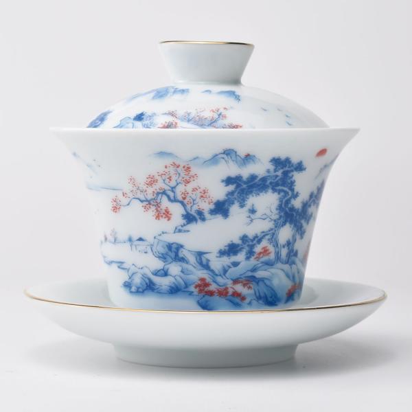 青みがかった下地に青と赤の山水の図案。釉の下に絵。