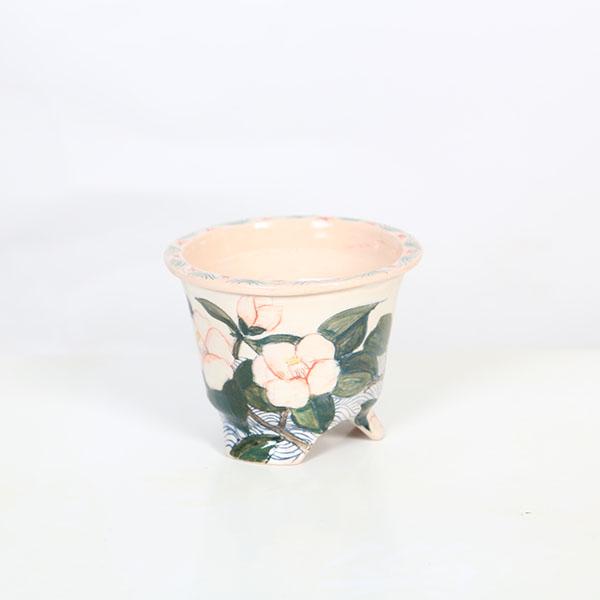 本田影雪　足付ケンガイ丸鉢本名：本田　榮子。落款：影雪幼いころより陶芸に興味があり、陶芸を始めて約30年。知人からの小品盆栽の鉢の依頼があり創作活動が始まりました。盆栽仲間のアドバイスや指導を受け自分の思い描くデザインや絵を鉢に描き楽しみな...