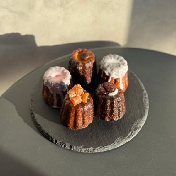 ラム酒香るボルドーカヌレ、勝沼産シャインマスカットのドライフルーツを使ったカヌレ、勝沼産桃のドライフルーツを使用したカヌレ、勝沼産赤白ワイン煮のカヌレの４種類からお選びいただけます。