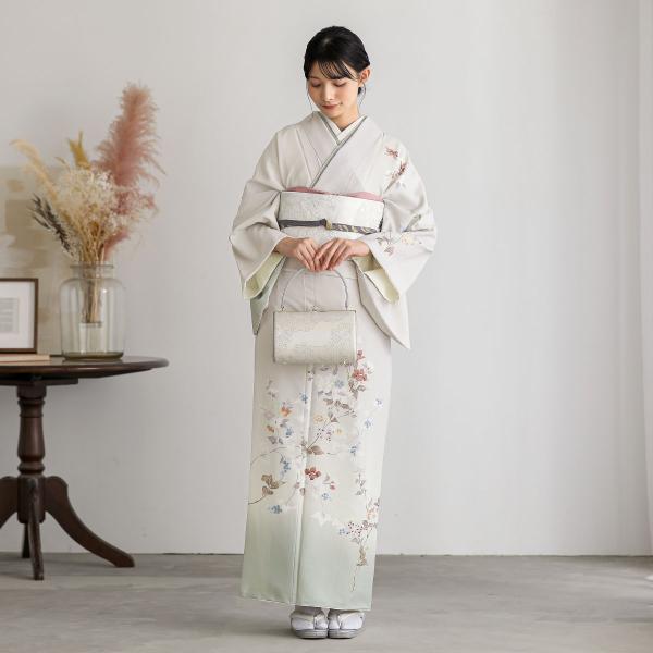 テイジンの生地を薄グレーとグリーンに暈し加賀調の訪問着。加賀友禅の伝統的な色使い「加賀五彩」＝臙脂・藍・黄土・草・古代紫を用いた繊細な染めが特徴で、華美になりすぎないトーンが魅力です。金箔や刺繍を使わず、自然の風景を写し取ったような柄行は、...