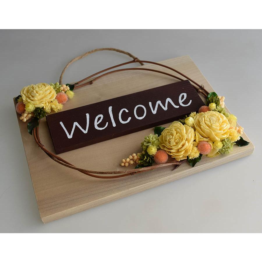 玄関ドアに イエロー系のお花のフレームアレンジ welcomeプレート付き
