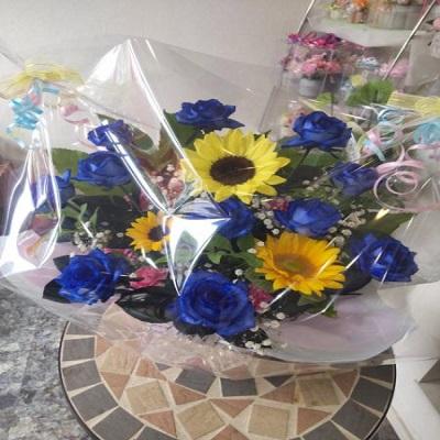 10本のブルーローズにひまわりを入れたアレンジを贈り物に | 