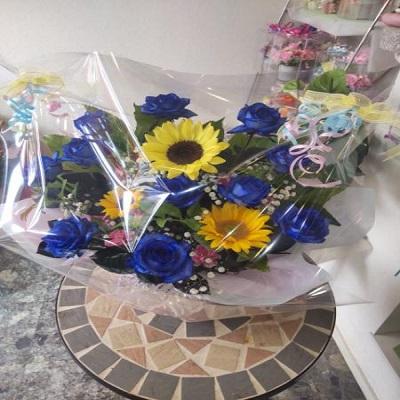 10本のブルーローズにひまわりを入れたアレンジを贈り物に |  | 05