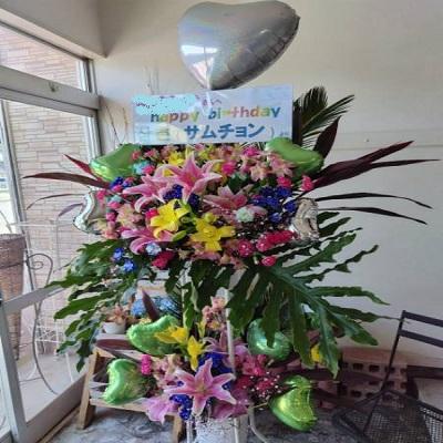 ピンクのゆりと季節のお花でハートのバルーン付きスタンド生花2段に！ |  | 02