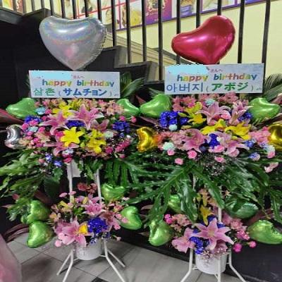 ピンクのゆりと季節のお花でハートのバルーン付きスタンド生花2段に！ |  | 08