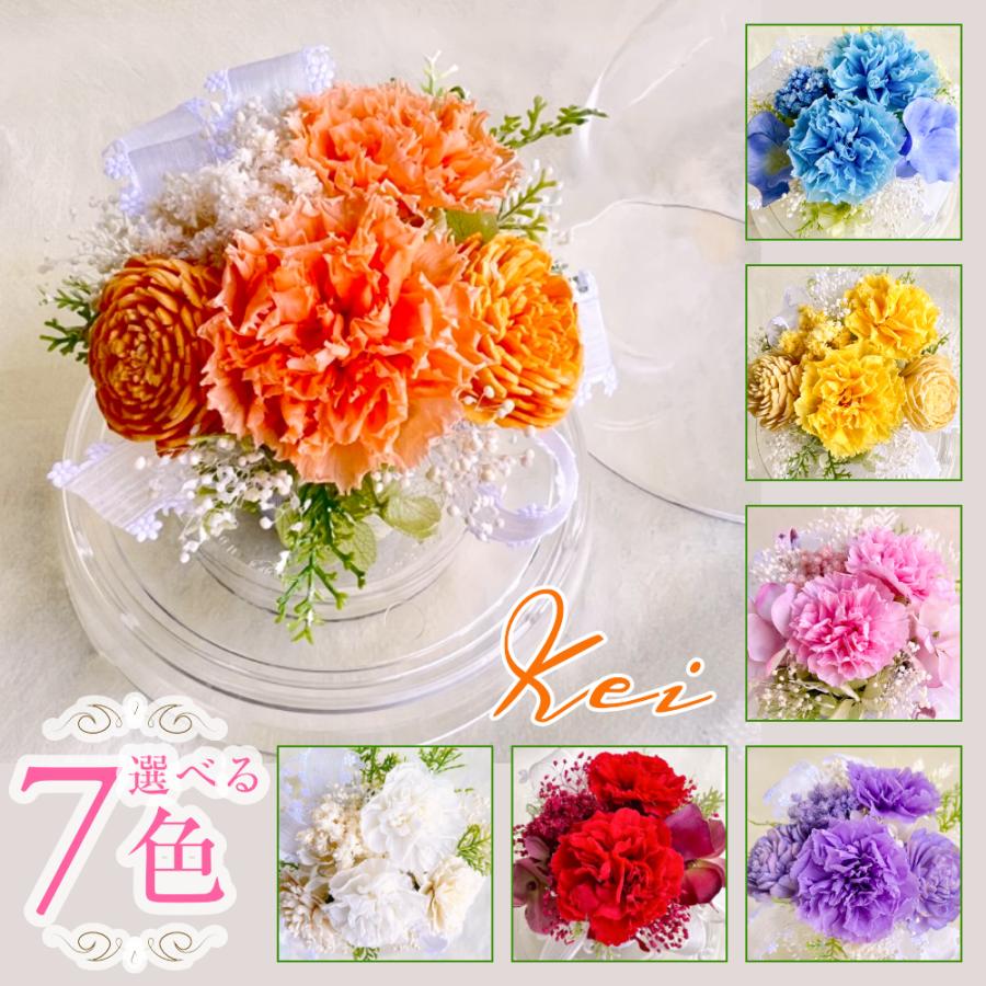 Mサイズのアクリルドームの中にカーネーションや小花を可憐にあしらった枯れない花飾り『Kei』です。プリザーブドフラワーですので水換えの心配なく、いつも美しいお花を眺めていられます。大切な方のお誕生日プレゼントはもちろん、母の日の贈り物としてもお薦めです。プリザーブドフラワーは本物のお花に長持ち加工を施したもので、日々のお水交換の負担がなく、贈り物としても大変喜ばれます。＜商品詳細＞●花材：プリザーブド素材（ローズ・クリスパム・カスミソウ・アジサイ）・アーティフィシャル（ソーラーカーネーション・リーフ）・リボン●色：オレンジ・イエロー・ベビーブルー・ラヴェンダー・ピンク・レッド・ホワイトの全7色●花器：ドーム（アクリル製）●サイズ：横幅13cm × 奥行13cm × 高さ15cm●用途：長持ちするため、お部屋を鮮やかに飾るインテリアにどうぞ。水交換不要で人が集まる環境にも。その他、お誕生日、結婚祝い、記念日、出産祝い、お見舞い、就職祝い、退職異動ギフト、感謝の気持ち、卒業・入学祝い、合格祝い、新築・引越し祝い、恩師やお稽古事の先生への御礼、お中元、クリスマス、お歳暮、母の日、父の日、敬老の日などのギフトに