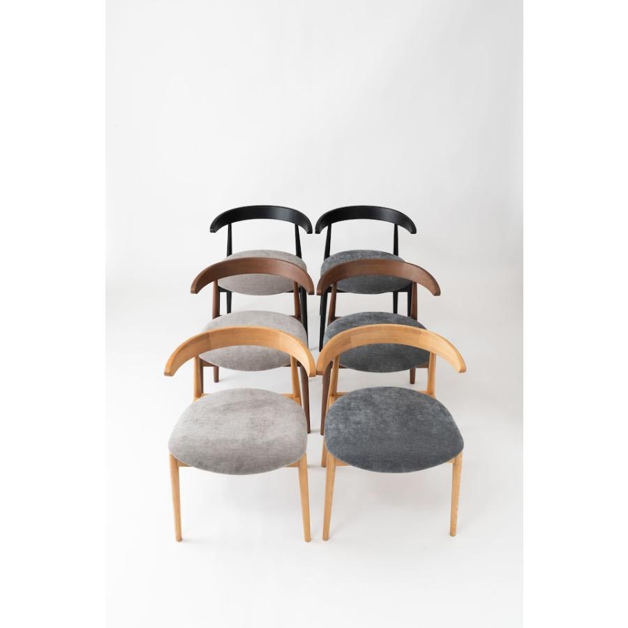 肘掛けをテーブルに掛けて脚を浮かせるシンプルモダンなダイニング