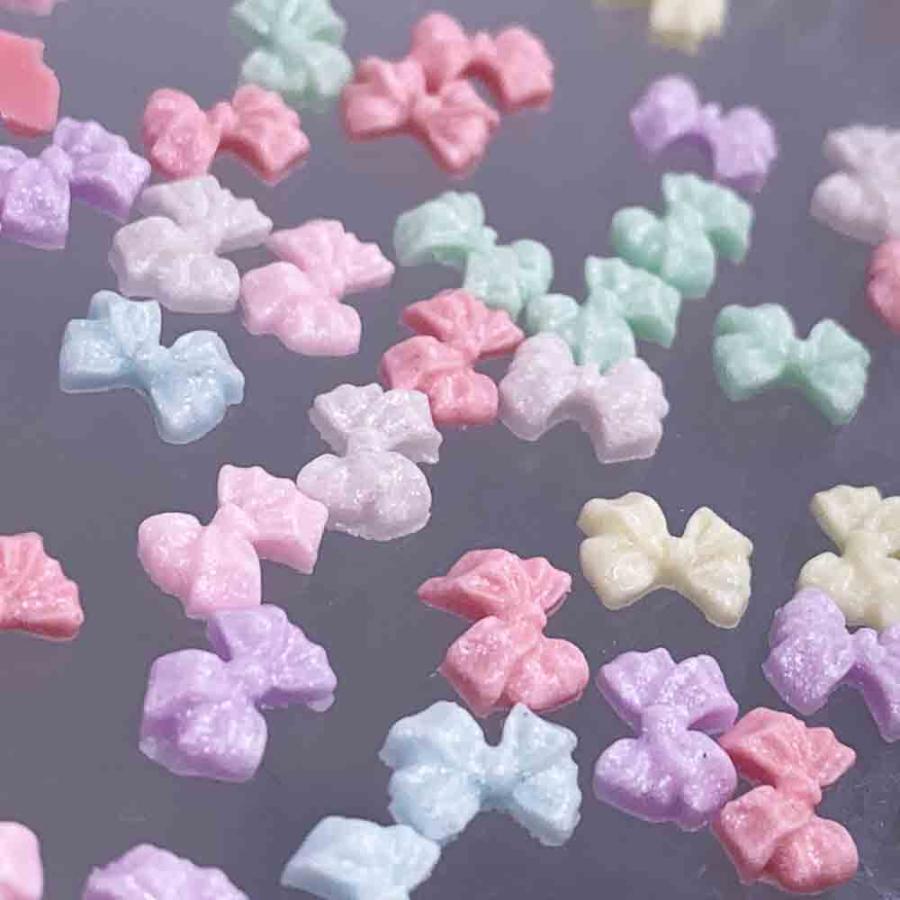 ネイルパーツ リボン 小さめ パステル 7mm 混色 光沢 100個 樹脂製