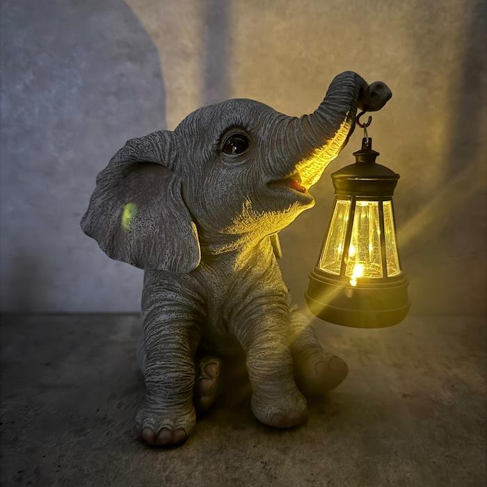 ゾウの置物 象の置物 ソーラーランプを鼻で持ち上げる赤ちゃんゾウ 高さ15.3cm