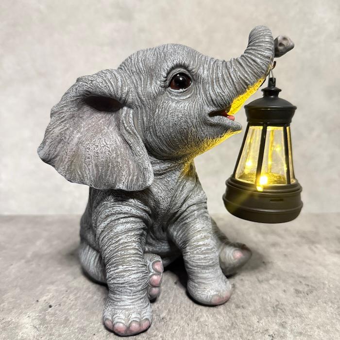 象の置物 ソーラーランプを鼻で持ち上げる赤ちゃんゾウ 高さ15.3cm