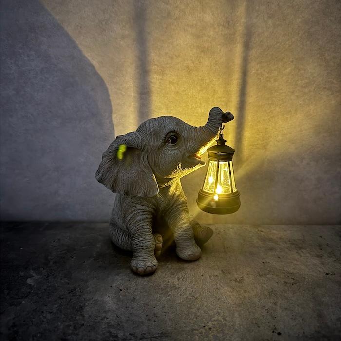 ゾウの置物 象の置物 ソーラーランプを鼻で持ち上げる赤ちゃんゾウ 高さ15.3cm