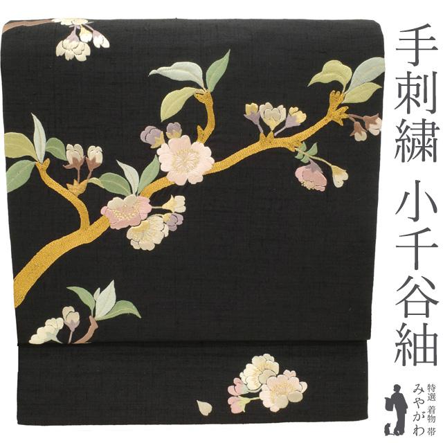 名古屋帯 九寸 小千谷紬 正絹 紬 黒地 ブラック系 桜 さくら 花 手刺繍 
