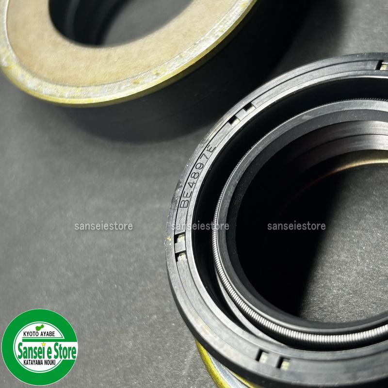 A genuine replacement rear axle oil seal set for a Mitsubishi tractor, photographed against a plain white background