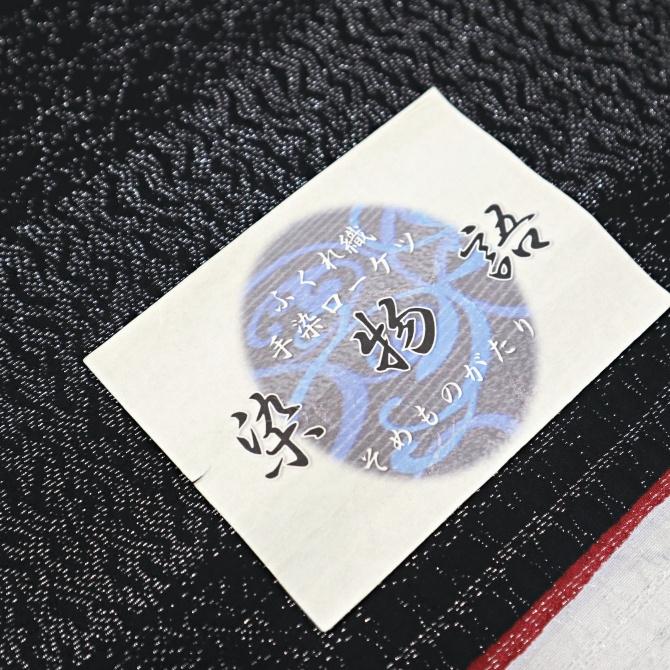 西陣織九寸名古屋帯　染物語　手染めローケツ  黒 赤 星  銀通し ふくれ織 日本製の画像
