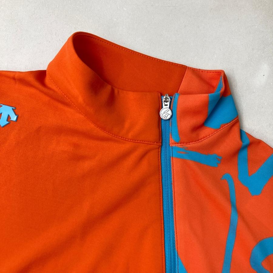 サイズ：M DESCENTE GOLF デサントゴルフ 万美コラボ 半袖ハーフジップTシャツ  オレンジ系 [240101415655] ゴルフウェア レディース ストスト DESCENTE GOLF 【新品】DESCENTE デサントゴルフ 万美コラボ 半袖