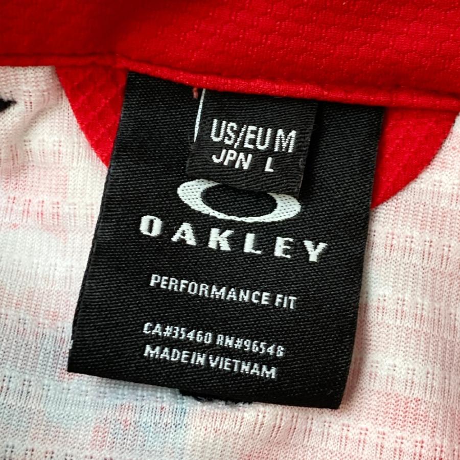サイズ：L OAKLEY オークリー  半袖ポロシャツ ボタンダウン スカル刺繍 総柄 レッド系 [240101486232] ゴルフウェア メンズ ストスト OAKLEY オークリー 半袖ポロシャツ ボタンダウン スカル刺繍 総